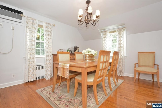 408 Eton Ct, Ridgewood, NJ 07450 - dining space with radiator, an AC wall unit, a chandelier, light wood-style flooring, and plenty of natural light