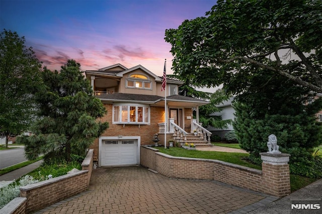 28 Elizabeth Ct, Secaucus, NJ 07094 - view of front facade featuring decorative driveway and a garage