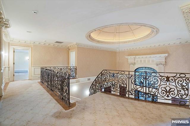 11 Margo Way, Alpine, NJ 07620 - corridor with an upstairs landing, ornamental molding, a raised ceiling, and a decorative wall