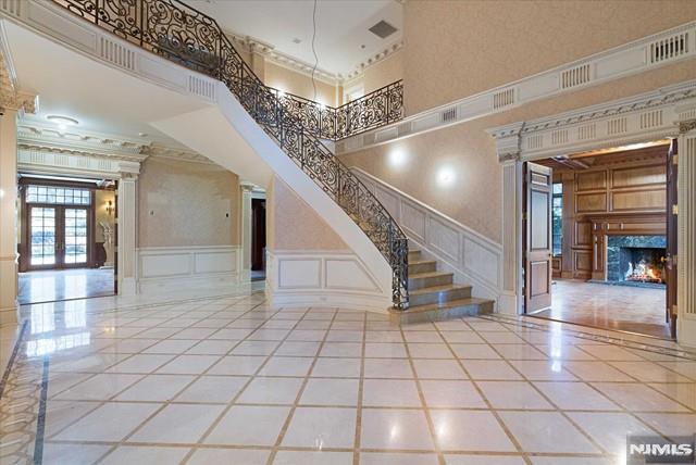 11 Margo Way, Alpine, NJ 07620 - entryway featuring a decorative wall, stairs, a fireplace, ornamental molding, and french doors