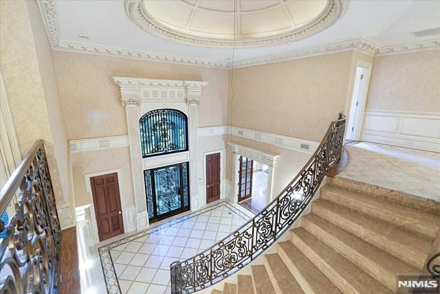 11 Margo Way, Alpine, NJ 07620 - foyer entrance with ornamental molding, a raised ceiling, stairway, a decorative wall, and a high ceiling