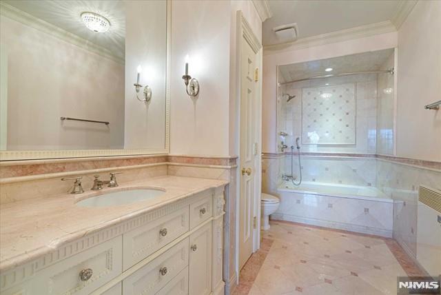 11 Margo Way, Alpine, NJ 07620 - full bathroom with vanity, ornamental molding, and shower / bathtub combination
