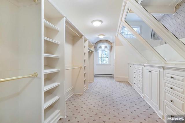 11 Margo Way, Alpine, NJ 07620 - spacious closet featuring baseboard heating, light carpet, and lofted ceiling