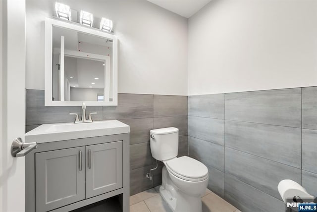 805 Fairview Ln, Fort Lee, NJ 07024 - bathroom featuring tile patterned flooring, toilet, tile walls, vanity, and wainscoting
