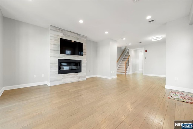 805 Fairview Ln, Fort Lee, NJ 07024 - unfurnished living room featuring light wood-style flooring, stairs, baseboards, a fireplace, and recessed lighting