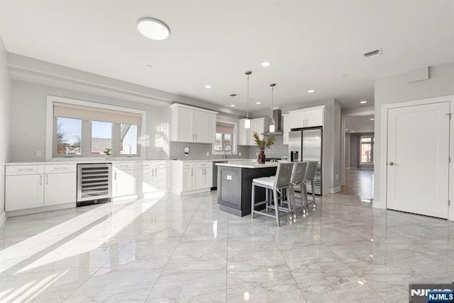 805 Fairview Ln, Fort Lee, NJ 07024 - kitchen featuring wine cooler, light marble finish flooring, appliances with stainless steel finishes, a kitchen island, and recessed lighting