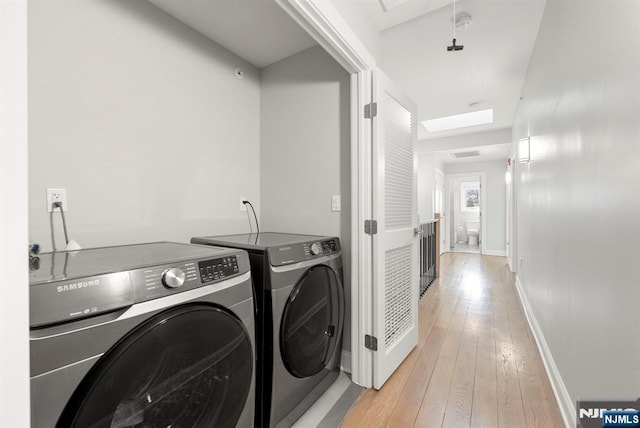805 Fairview Ln, Fort Lee, NJ 07024 - laundry area featuring washer and clothes dryer, light wood-style floors, baseboards, and a skylight