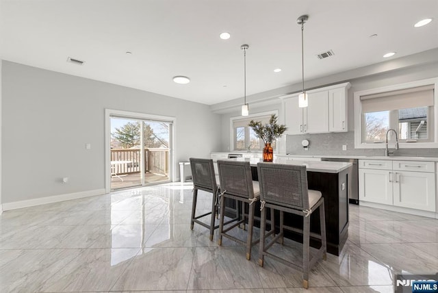 805 Fairview Ln, Fort Lee, NJ 07024 - kitchen with light marble finish floors, a center island, light countertops, a sink, and baseboards