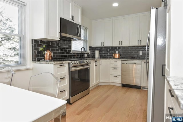 11-06 Marshall Rd, Fair Lawn, NJ 07410 - kitchen featuring stainless steel appliances, light wood-style floors, decorative backsplash, plenty of natural light, and recessed lighting