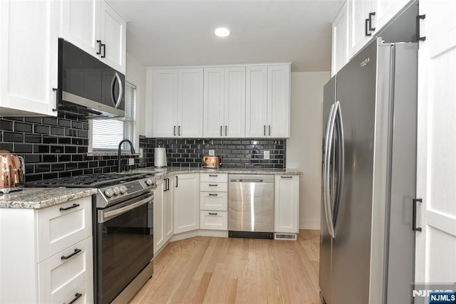 11-06 Marshall Rd, Fair Lawn, NJ 07410 - kitchen featuring stainless steel appliances, light wood-style floors, white cabinets, decorative backsplash, and recessed lighting