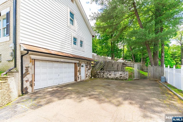 72 Francisco Ave, Little Falls, NJ 07424 - view of side of property with a garage, driveway, and stone siding