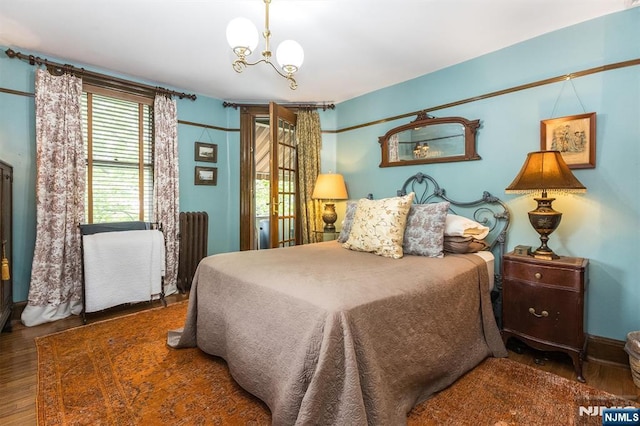 33 Ramapo Ave, Pompton Lakes, NJ 07442 - bedroom with radiator, a chandelier, and wood finished floors