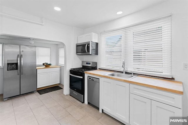 1146 Stasia St, Teaneck, NJ 07666 - kitchen featuring wooden counters, stainless steel appliances, white cabinets, light tile patterned floors, and recessed lighting