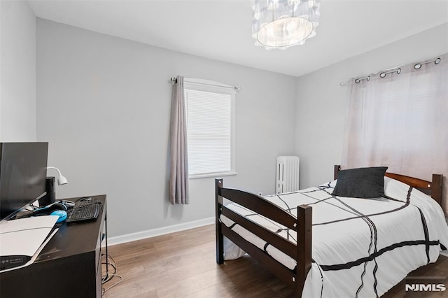 1146 Stasia St, Teaneck, NJ 07666 - bedroom featuring radiator, wood finished floors, and a chandelier