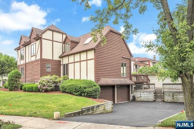 23 Bohnert Pl, Waldwick, NJ 07463 - view of property exterior with stucco siding, a yard, driveway, and an attached garage