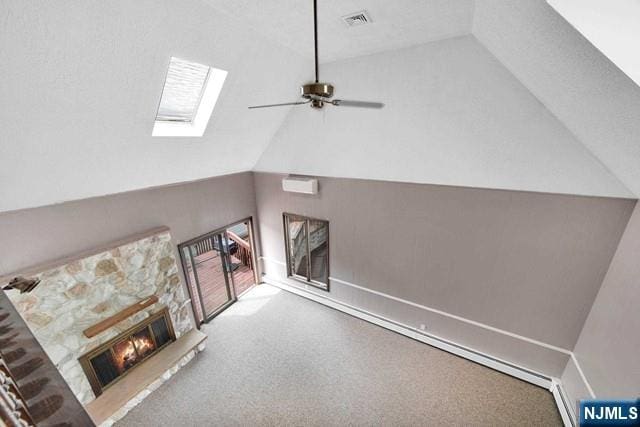 23 Bohnert Pl, Waldwick, NJ 07463 - unfurnished living room with lofted ceiling, an AC wall unit, a skylight, a stone fireplace, and a ceiling fan