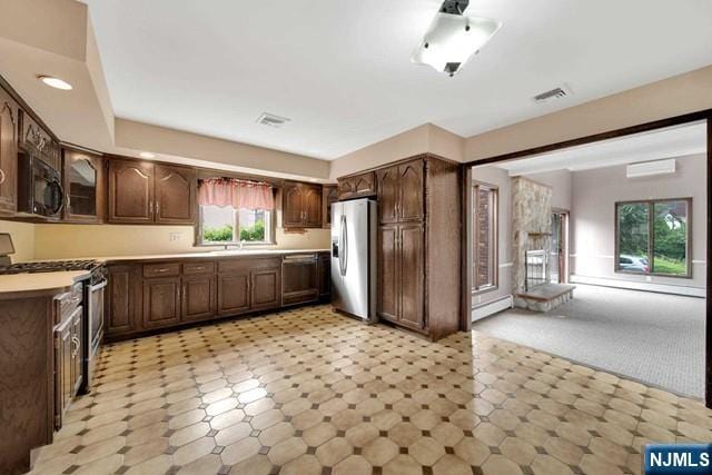 23 Bohnert Pl, Waldwick, NJ 07463 - kitchen with appliances with stainless steel finishes, a baseboard radiator, an AC wall unit, and light countertops