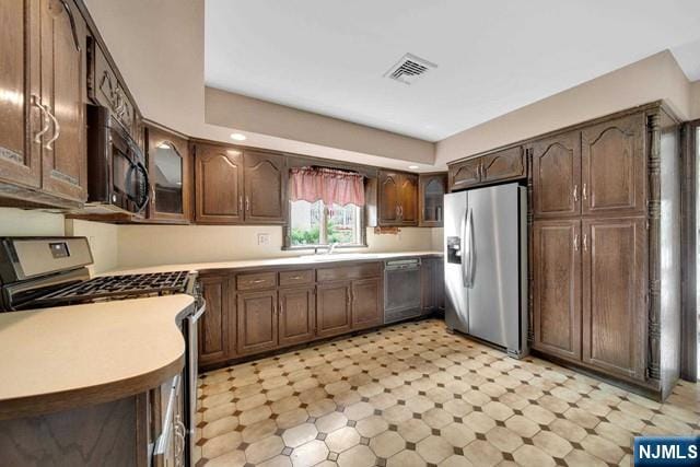 23 Bohnert Pl, Waldwick, NJ 07463 - kitchen with appliances with stainless steel finishes, light flooring, light countertops, and glass insert cabinets