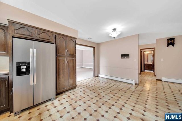 23 Bohnert Pl, Waldwick, NJ 07463 - kitchen featuring stainless steel refrigerator with ice dispenser, a baseboard radiator, light flooring, and dark brown cabinetry