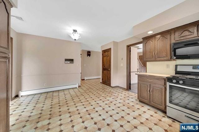 23 Bohnert Pl, Waldwick, NJ 07463 - kitchen with stainless steel range with gas stovetop, black microwave, baseboard heating, baseboards, and light countertops