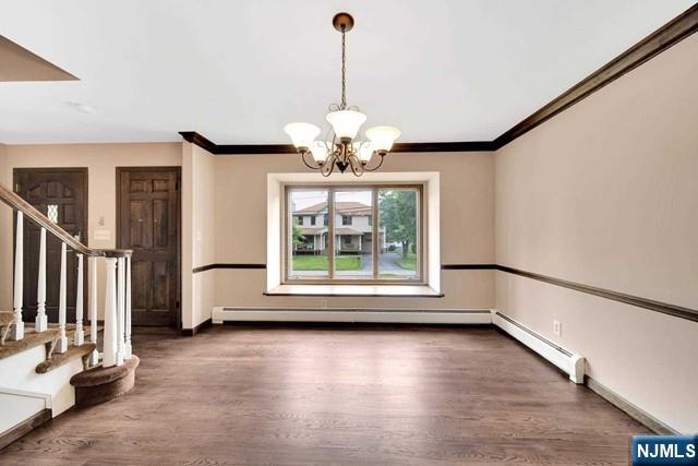 23 Bohnert Pl, Waldwick, NJ 07463 - unfurnished dining area with stairs, wood finished floors, a chandelier, crown molding, and baseboards