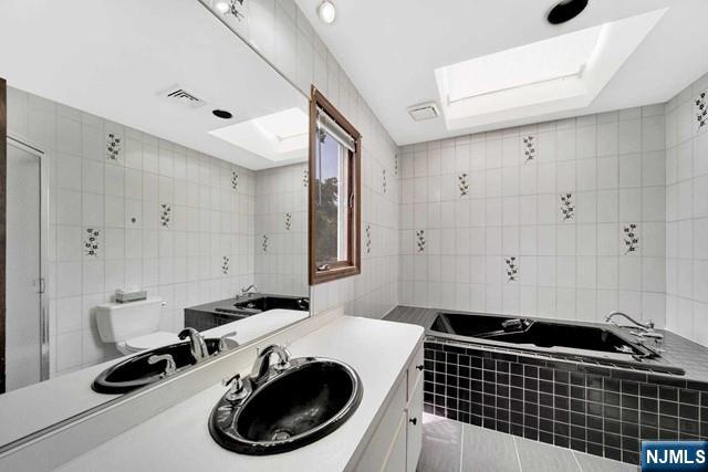 23 Bohnert Pl, Waldwick, NJ 07463 - full bath with tile walls, a bath, toilet, vanity, and tile patterned flooring