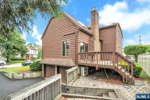 23 Bohnert Pl, Waldwick, NJ 07463 - back of house featuring a chimney, driveway, a wooden deck, and an attached garage