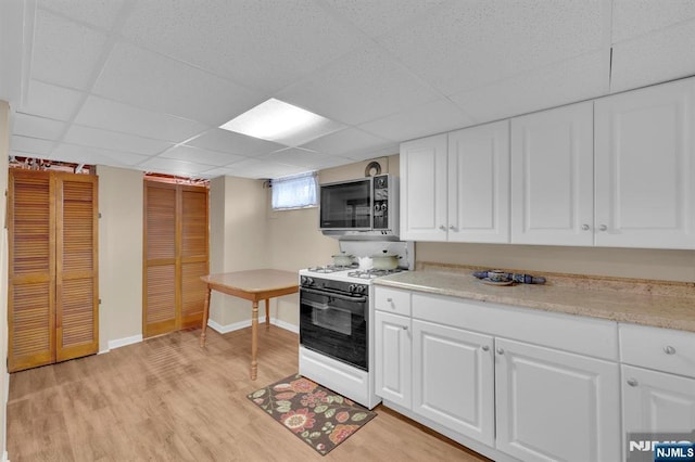 13 Wonham St, Clifton, NJ 07013 - kitchen featuring white gas range, a drop ceiling, light wood-style floors, light countertops, and baseboards