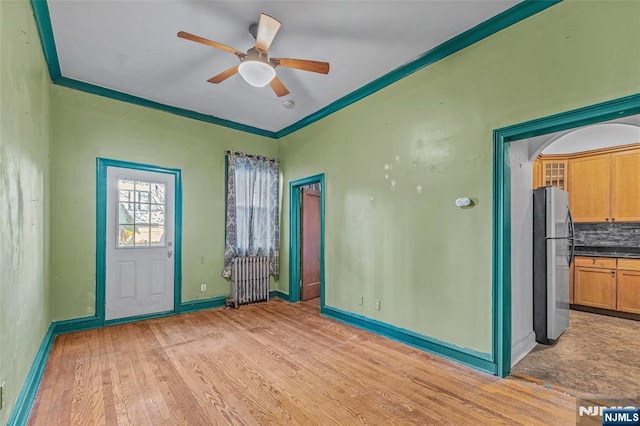 300 2nd St Unit 2, Jersey City, NJ 07302 - unfurnished room with ceiling fan, light wood finished floors, baseboards, radiator heating unit, and crown molding