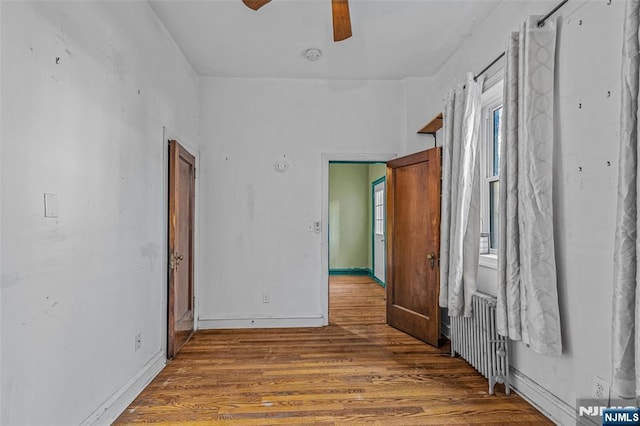 300 2nd St Unit 2, Jersey City, NJ 07302 - unfurnished bedroom featuring radiator heating unit, wood finished floors, a ceiling fan, and baseboards