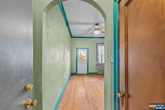 300 2nd St Unit 2, Jersey City, NJ 07302 - hall with wood finished floors, arched walkways, baseboards, crown molding, and radiator heating unit