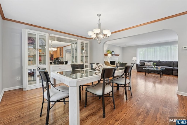 13 Stonewall Dr, Livingston, NJ 07039 - dining room featuring a chandelier, baseboards, arched walkways, wood finished floors, and ornamental molding