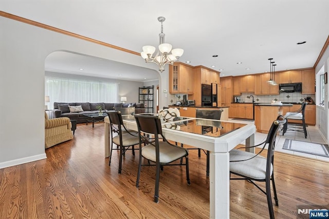 13 Stonewall Dr, Livingston, NJ 07039 - dining space featuring arched walkways, a chandelier, light wood-type flooring, recessed lighting, and crown molding