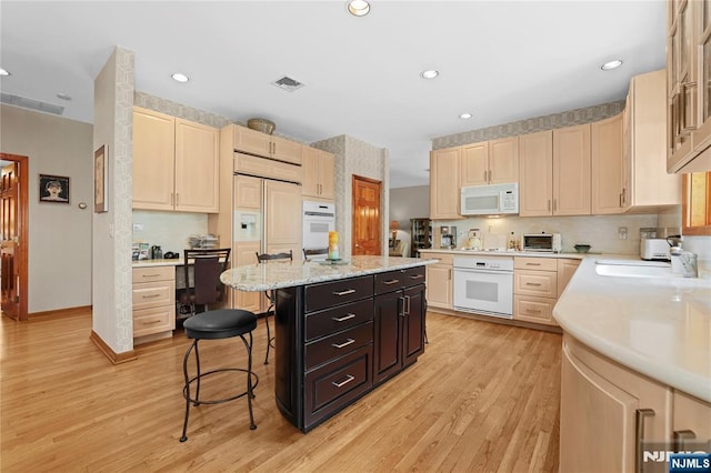 12 Woodland Ct, Wayne, NJ 07470 - kitchen with white appliances, a kitchen breakfast bar, a kitchen island, light brown cabinetry, and recessed lighting