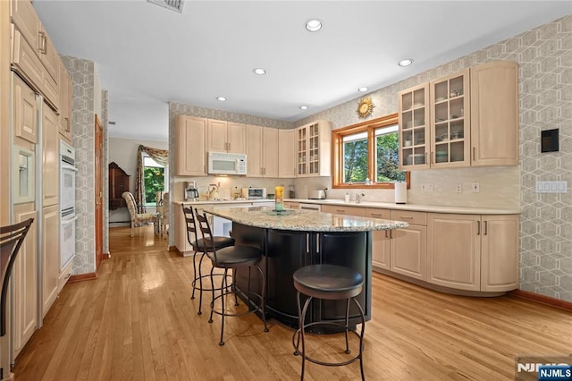 12 Woodland Ct, Wayne, NJ 07470 - kitchen with white appliances, a kitchen bar, light wood finished floors, a kitchen island, and recessed lighting