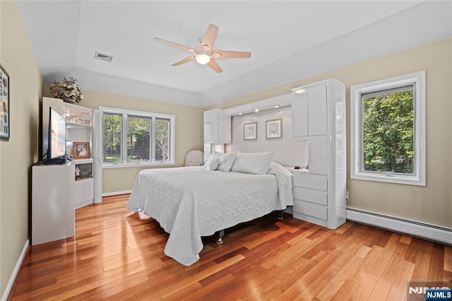 12 Woodland Ct, Wayne, NJ 07470 - bedroom featuring multiple windows, a baseboard heating unit, and light wood-style floors