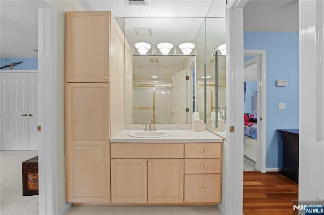 12 Woodland Ct, Wayne, NJ 07470 - ensuite bathroom featuring vanity, baseboards, wood finished floors, and a shower with shower door