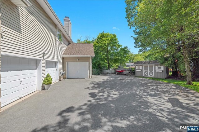 12 Woodland Ct, Wayne, NJ 07470 - garage with a storage unit and driveway