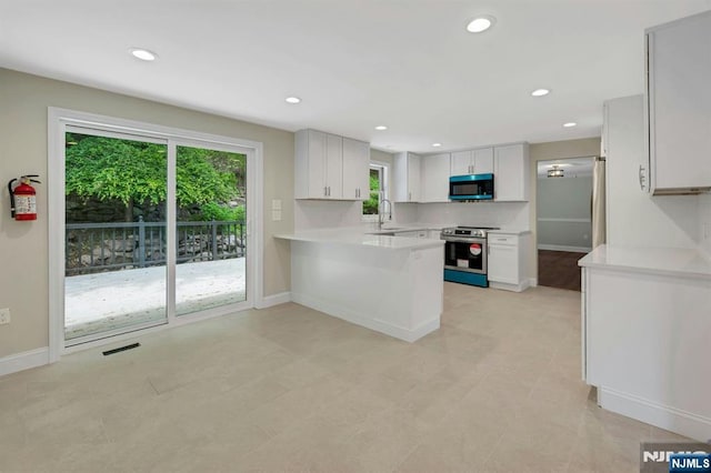1582 Grnwd Lk, West Milford, NJ 07421 - kitchen featuring stainless steel appliances, a sink, light countertops, a peninsula, and baseboards