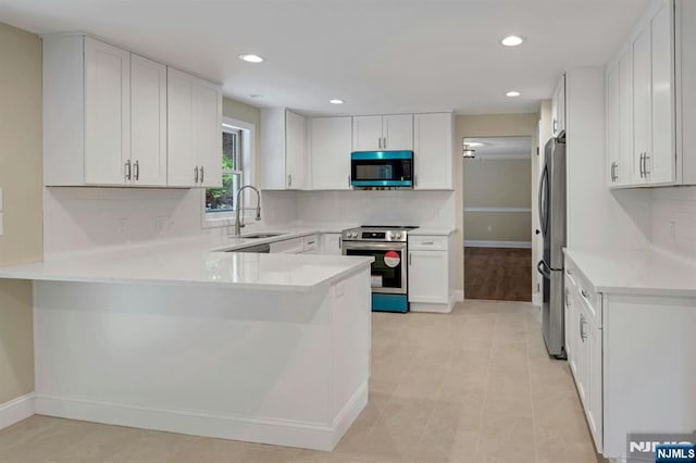 1582 Grnwd Lk, West Milford, NJ 07421 - kitchen featuring appliances with stainless steel finishes, a sink, a peninsula, baseboards, and recessed lighting