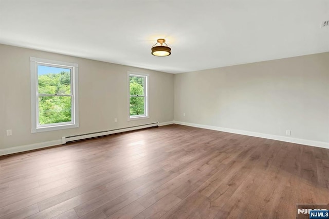 1582 Grnwd Lk, West Milford, NJ 07421 - empty room with baseboard heating, healthy amount of natural light, wood finished floors, and baseboards