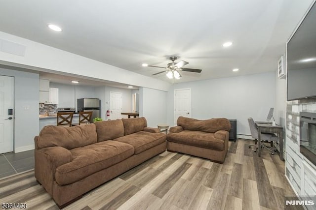 5 Britton St, Netcong Borough, NJ 07857 - living area with a baseboard heating unit, ceiling fan, recessed lighting, a glass covered fireplace, and light wood-type flooring