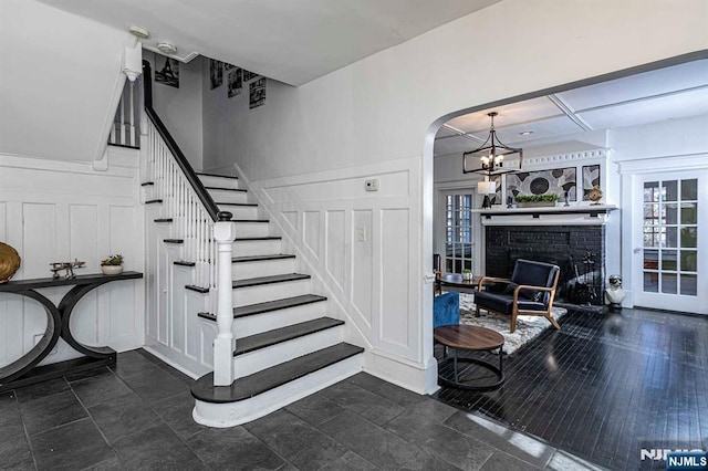 10 Whittier Ave, Trenton, NJ 08618 - stairway with arched walkways, a chandelier, healthy amount of natural light, and a brick fireplace