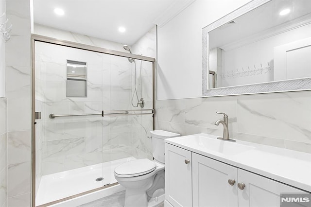 309 Clinton Ave, Bergenfield, NJ 07621 - full bathroom with tile walls, a marble finish shower, vanity, recessed lighting, and marble look tiles