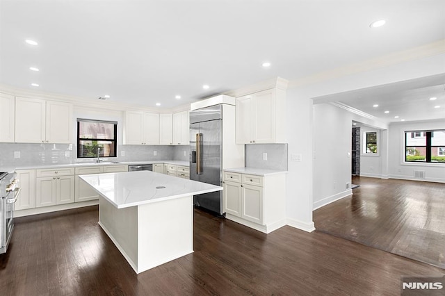 309 Clinton Ave, Bergenfield, NJ 07621 - kitchen with plenty of natural light, light countertops, tasteful backsplash, stainless steel appliances, and ornamental molding