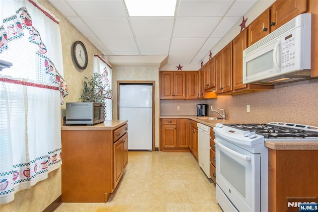 41 Gillies St, Clifton, NJ 07013 - kitchen featuring white appliances, a paneled ceiling, brown cabinetry, light countertops, and a sink