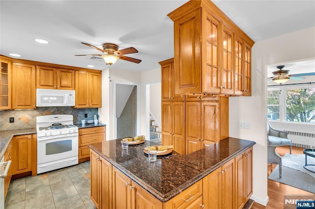 8 Delmar Ave, Cresskill, NJ 07626 - kitchen with white appliances, ceiling fan, radiator heating unit, decorative backsplash, and glass insert cabinets