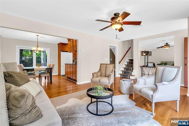 8 Delmar Ave, Cresskill, NJ 07626 - living room featuring a ceiling fan, a chandelier, light wood-style flooring, and stairway