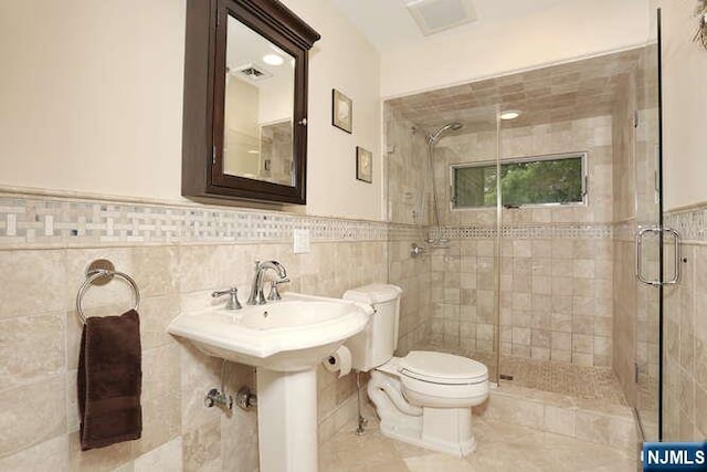 55 Beech St, Westwood, NJ 07675 - full bathroom with a shower stall, wainscoting, tile walls, and tile patterned flooring