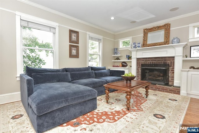  - living area with crown molding, a brick fireplace, and wood finished floors